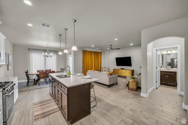 323 N 2020 W Unit 38, Hurricane, UT 84737 - kitchen featuring dark brown cabinetry, sink, a center island with sink, ceiling fan with notable chandelier, and appliances with stainless steel finishes