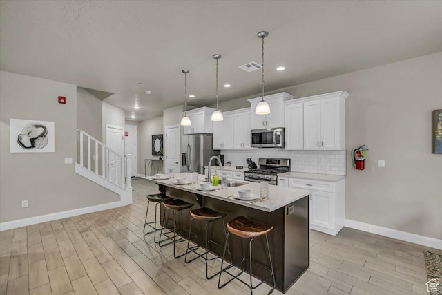 323 N 2020 W Unit 38, Hurricane, UT 84737 - kitchen featuring a kitchen bar, white cabinetry, stainless steel appliances, and a kitchen island with sink