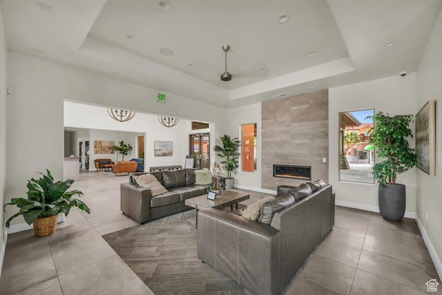 323 N 2020 W Unit 38, Hurricane, UT 84737 - living room featuring a tray ceiling, a tiled fireplace, light tile patterned floors, and a healthy amount of sunlight