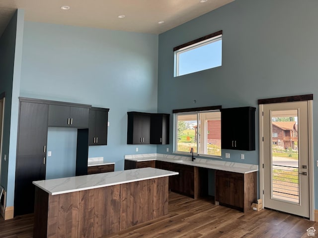 2584 S Country Club Dr Unit 12, Garden City, UT 84028 - kitchen featuring a high ceiling, wood finished floors, a center island, light stone counters, and recessed lighting