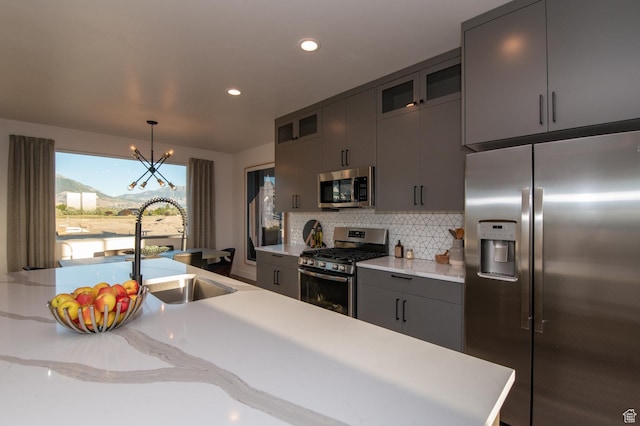 kitchen featuring backsplash, stainless steel appliances, a sink, and light countertops