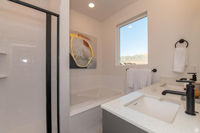 full bath with a stall shower, recessed lighting, a garden tub, and vanity
