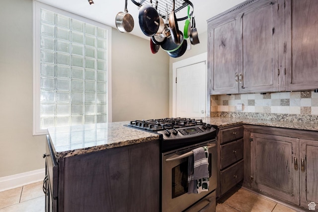 211 N 200 W, Salt Lake City, UT 84103 - kitchen with stainless steel gas range oven, decorative backsplash, light tile patterned floors, dark brown cabinets, and light stone counters