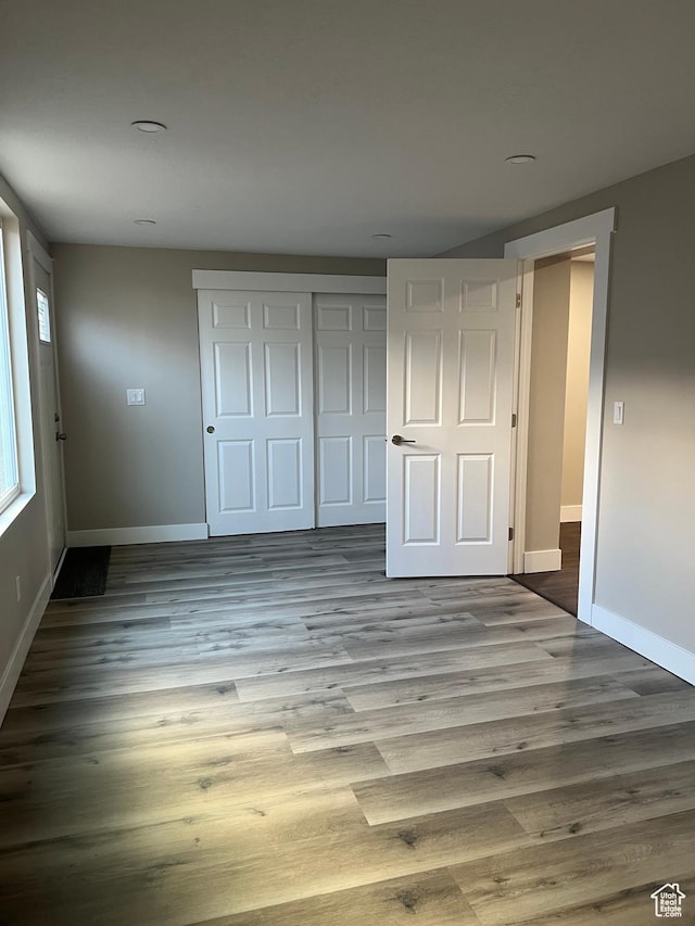 unfurnished bedroom featuring light hardwood / wood-style flooring and a closet