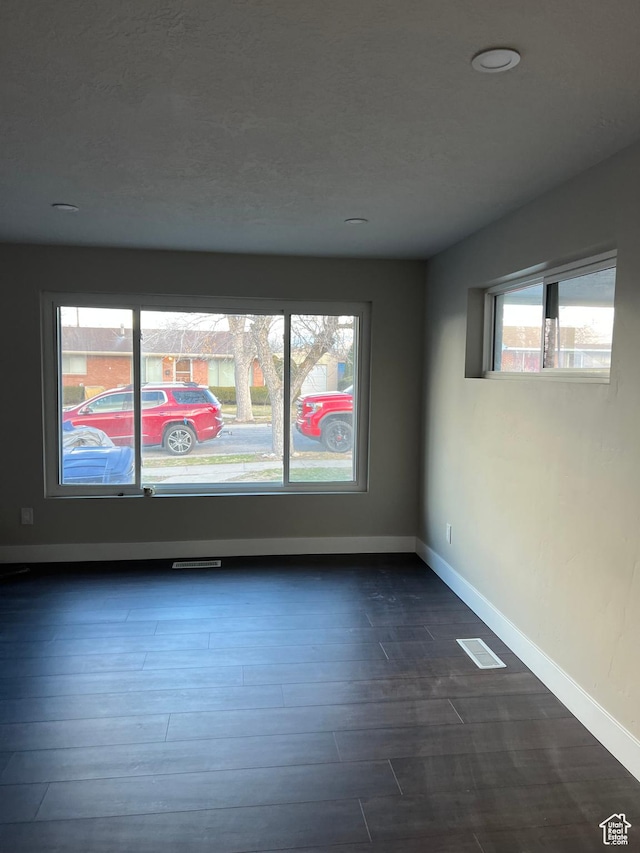 spare room with dark wood-type flooring
