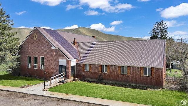 1518 E 9000 N, Preston, ID 83263 - view of front of house with brick siding, a front yard, and metal roof