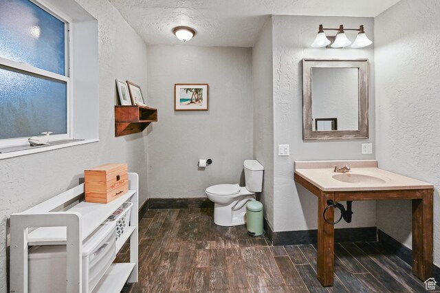 1518 E 9000 N, Preston, ID 83263 - bathroom with wood finished floors, a textured wall, toilet, a sink, and a textured ceiling
