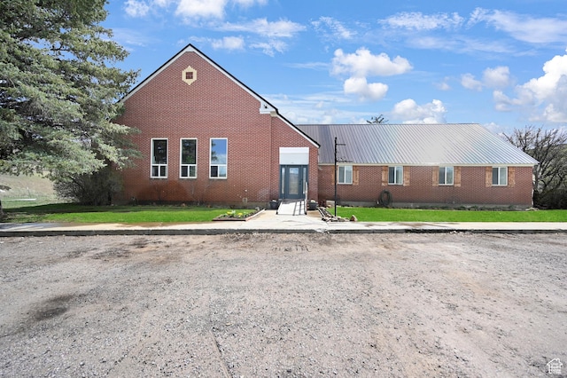 1518 E 9000 N, Preston, ID 83263 - view of front of home featuring a front lawn, brick siding, and metal roof