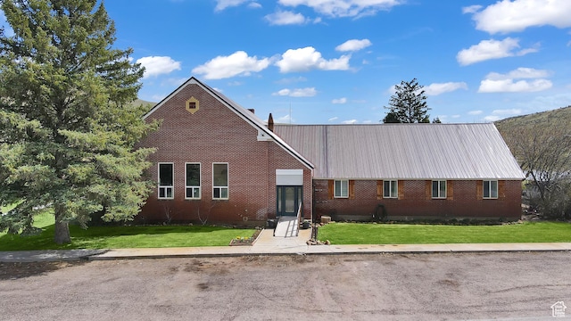 1518 E 9000 N, Preston, ID 83263 - view of front of house featuring brick siding, a front yard, and metal roof
