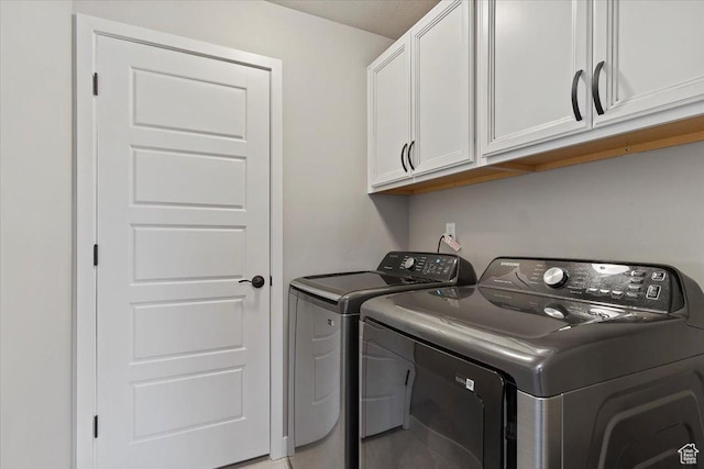 laundry room featuring separate washer and dryer and cabinet space