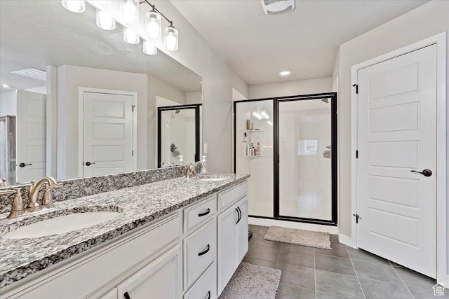 bathroom featuring tile patterned floors, a shower stall, double vanity, and a sink