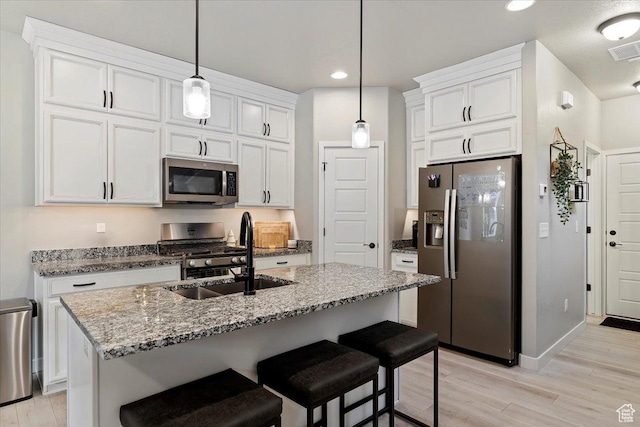 kitchen featuring visible vents, light wood-style floors, appliances with stainless steel finishes, and a sink