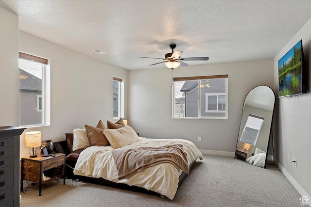 bedroom featuring visible vents, light carpet, baseboards, and multiple windows