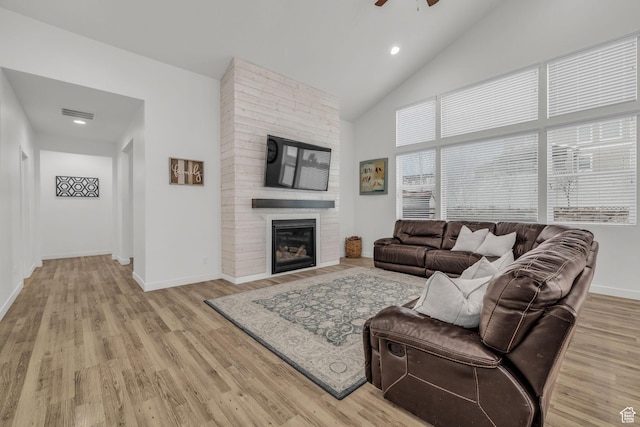 13456 S Rowell Dr, Herriman, UT 84096 - living area with a ceiling fan, high vaulted ceiling, light wood-type flooring, a large fireplace, and recessed lighting