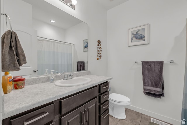 bathroom featuring vanity, tile patterned floors, and toilet