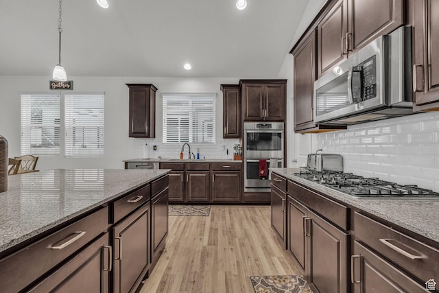 kitchen featuring sink, decorative light fixtures, dark brown cabinets, and stainless steel appliances