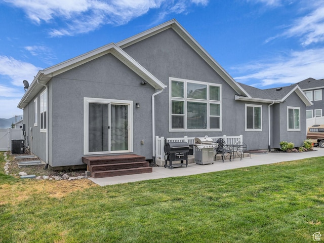 13456 S Rowell Dr, Herriman, UT 84096 - rear view of house with stucco siding, a lawn, a patio area, and entry steps