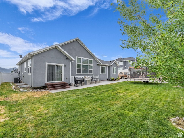 13456 S Rowell Dr, Herriman, UT 84096 - back of property with a trampoline, a patio area, stucco siding, a gate, and entry steps