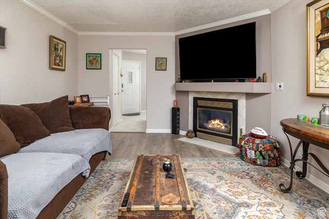 28 N River Pointe Dr, Logan, UT 84321 - living room with ornamental molding, a fireplace with flush hearth, wood finished floors, baseboards, and a textured ceiling