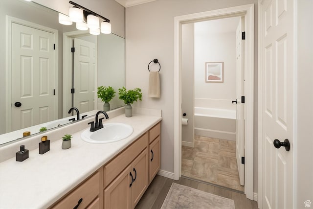 28 N River Pointe Dr, Logan, UT 84321 - full bath featuring vanity, baseboards, a tub to relax in, and wood finished floors