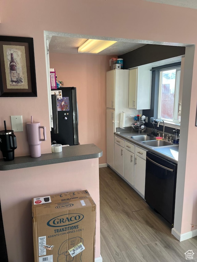 3134 S Buena Verde Ln, Magna, UT 84044 - kitchen featuring light hardwood / wood-style floors, black appliances, sink, a textured ceiling, and white cabinets