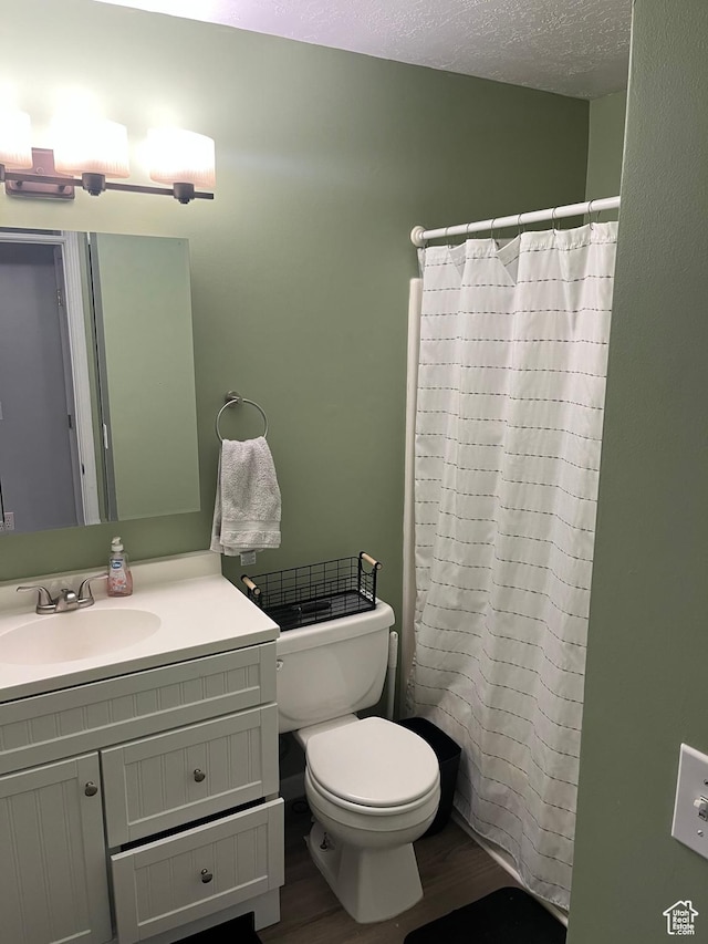3134 S Buena Verde Ln, Magna, UT 84044 - bathroom featuring toilet, hardwood / wood-style flooring, walk in shower, a textured ceiling, and vanity