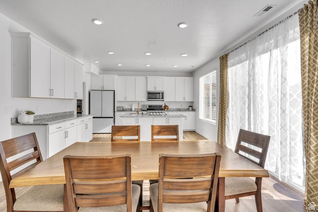 1025 S 850 W, American Fork, UT 84003 - kitchen featuring white cabinets, appliances with stainless steel finishes, light wood-type flooring, and light stone counters