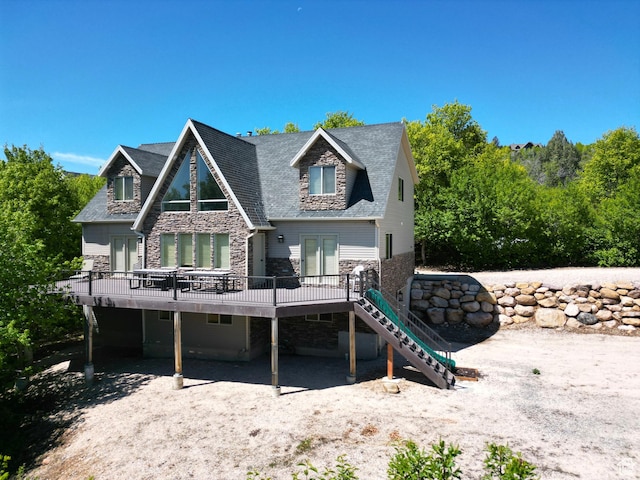 2310 S Sweetwater Pkwy Unit 5, Garden City, UT 84028 - rear view of house with stone siding, a wooden deck, and stairs