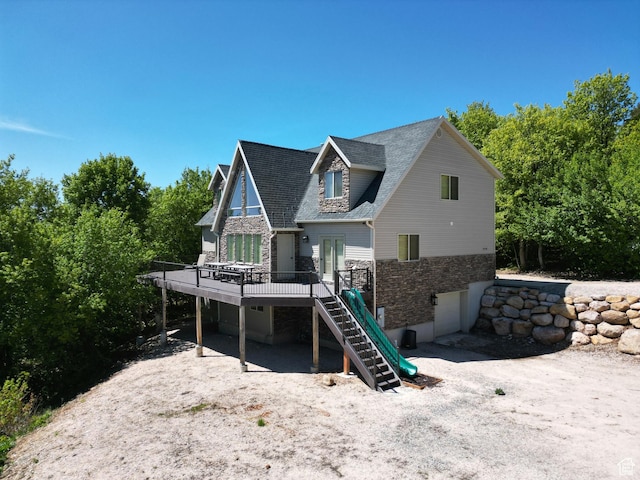 2310 S Sweetwater Pkwy Unit 5, Garden City, UT 84028 - back of house with stairway, a deck, stone siding, and a shingled roof