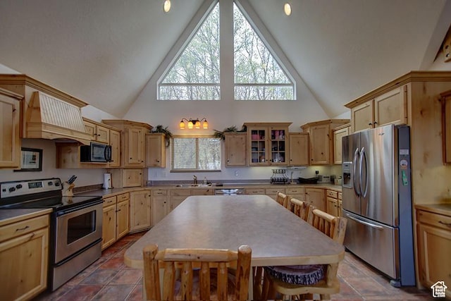 2310 S Sweetwater Pkwy Unit 5, Garden City, UT 84028 - kitchen featuring stainless steel appliances, high vaulted ceiling, a sink, light brown cabinets, and custom exhaust hood