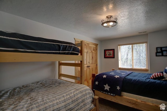 2310 S Sweetwater Pkwy Unit 5, Garden City, UT 84028 - carpeted bedroom featuring a textured ceiling