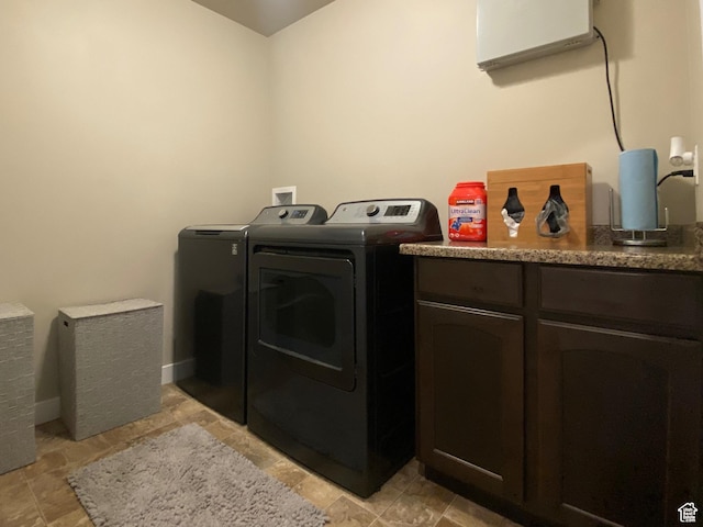 clothes washing area with cabinets and washer and dryer
