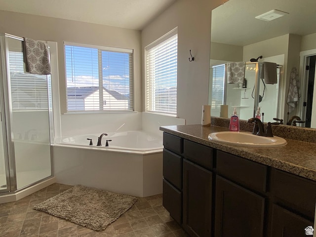 bathroom with vanity and independent shower and bath