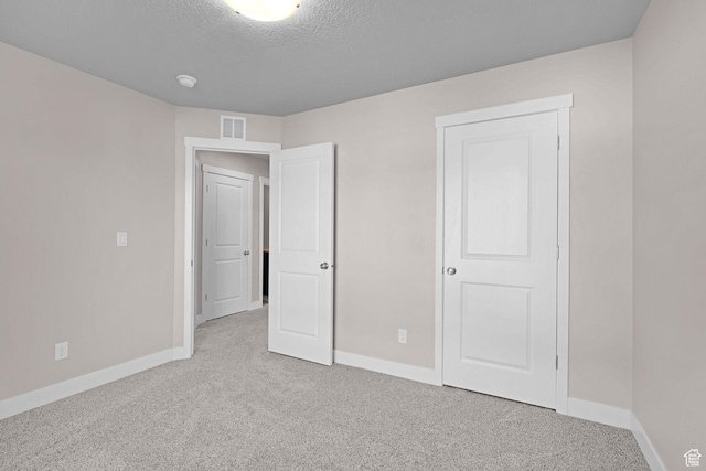 unfurnished bedroom with carpet and a textured ceiling