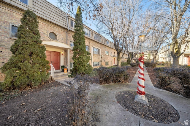 2220 E Murray Holladay Rd Unit 122, Salt Lake City, UT 84117 - view of property exterior with mansard roof, brick siding, and a residential view