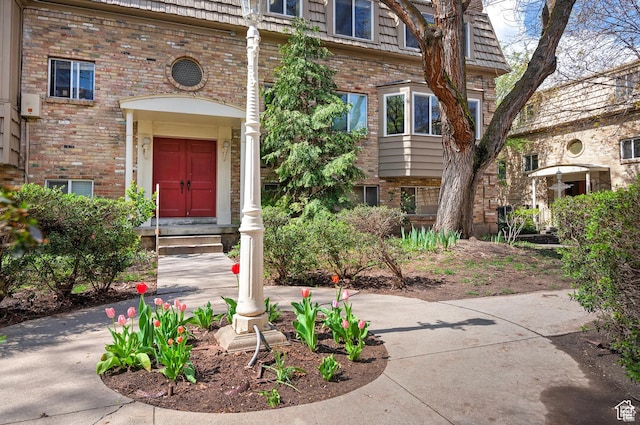 2220 E Murray Holladay Rd Unit 122, Salt Lake City, UT 84117 - doorway to property with brick siding and mansard roof