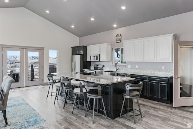 2923 S Country Club Way Unit 46, Garden City, UT 84028 - kitchen with stainless steel appliances, a center island, high vaulted ceiling, french doors, and a breakfast bar