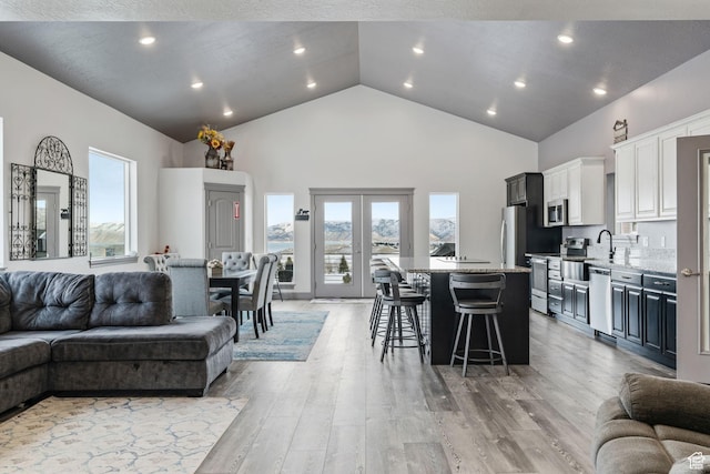 2923 S Country Club Way Unit 46, Garden City, UT 84028 - living room with high vaulted ceiling, light wood-style floors, french doors, and recessed lighting
