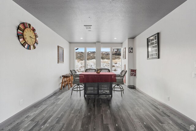 2923 S Country Club Way Unit 46, Garden City, UT 84028 - dining room featuring wood finished floors, a textured ceiling, and baseboards