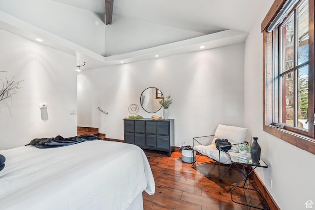 bedroom featuring multiple windows, hardwood / wood-style floors, and lofted ceiling with beams