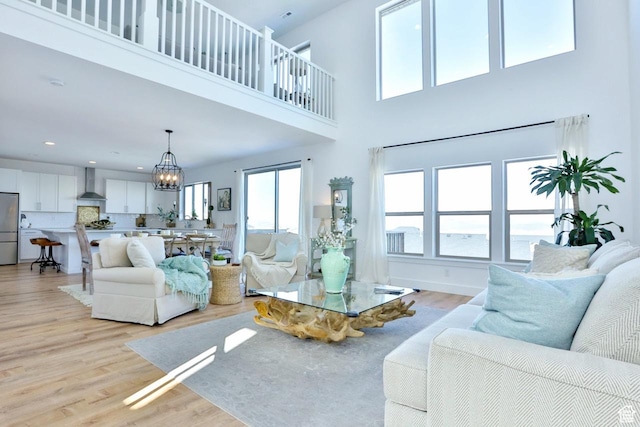 3234 S Iron Hill Cir S, Saratoga Springs, UT 84045 - living area with a chandelier, light wood-style flooring, and a towering ceiling