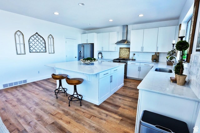 3234 S Iron Hill Cir S, Saratoga Springs, UT 84045 - kitchen with stainless steel appliances, a sink, wall chimney exhaust hood, a kitchen breakfast bar, and a center island