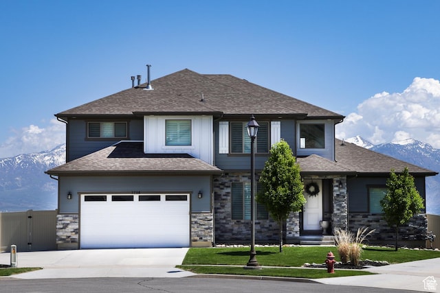 view of front of house featuring a mountain view, a garage, and a front yard