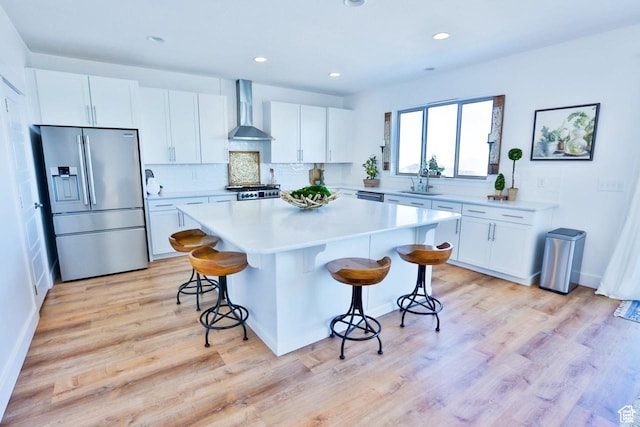 3234 S Iron Hill Cir S, Saratoga Springs, UT 84045 - kitchen featuring stainless steel fridge, wall chimney exhaust hood, a breakfast bar, a center island, and white cabinets