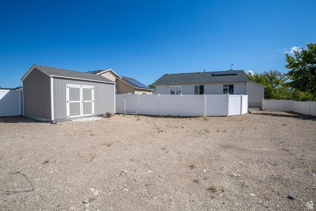 view of yard featuring a storage shed, an outdoor structure, and a fenced backyard