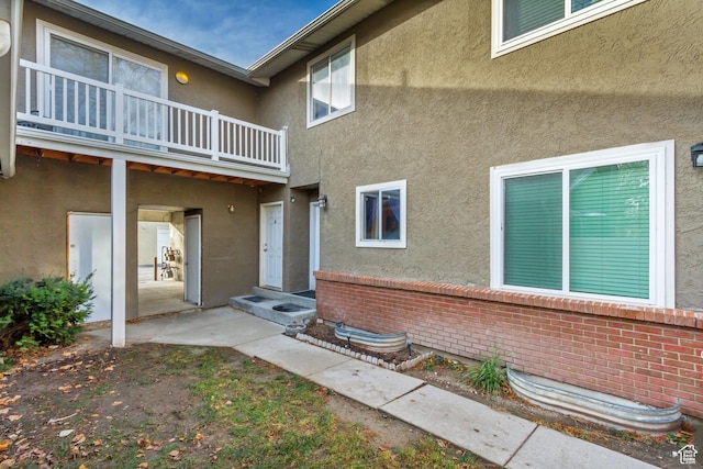 view of exterior entry featuring a balcony