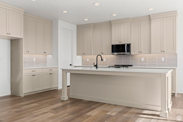 2149 W 3930 S, Hurricane, UT 84737 - kitchen featuring stainless steel microwave, light wood-type flooring, a sink, light countertops, and recessed lighting