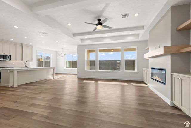 2149 W 3930 S, Hurricane, UT 84737 - unfurnished living room featuring a glass covered fireplace, light wood-style floors, a ceiling fan, recessed lighting, and a sink