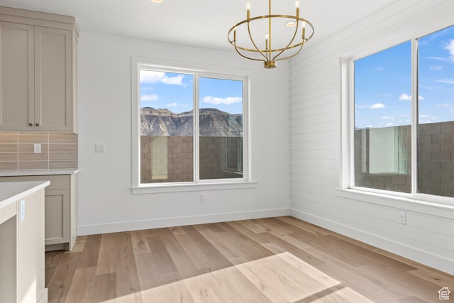 2149 W 3930 S, Hurricane, UT 84737 - unfurnished dining area featuring a chandelier, light wood-style floors, baseboards, and a mountain view