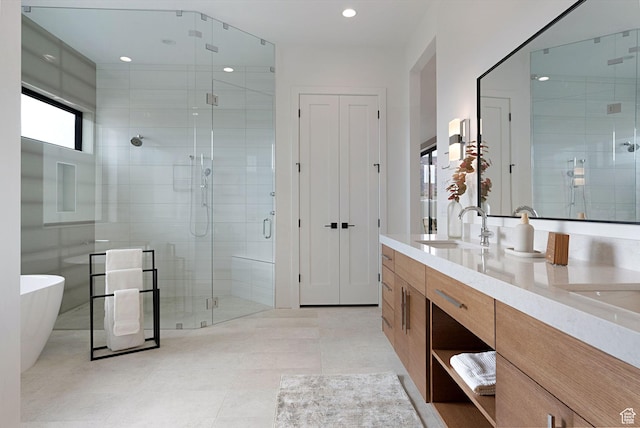 bathroom with tile patterned floors, vanity, and shower with separate bathtub